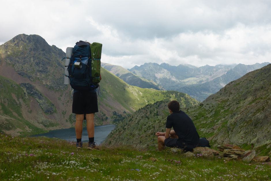 Two hikers admire the stunning mountain landscape, perfect for adventure seekers.